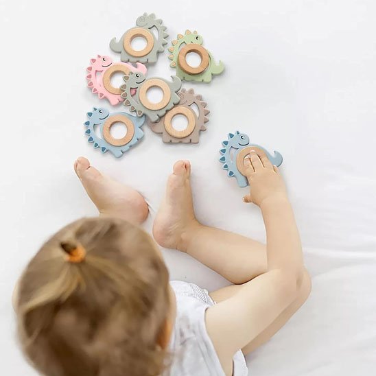 Anneau de dentition en silicone alimentaire tenu par un bébé pendant les poussées dentaires