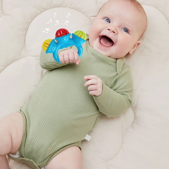 Bébé allongé sur le dos tenant un hochet bébé bleu et vert