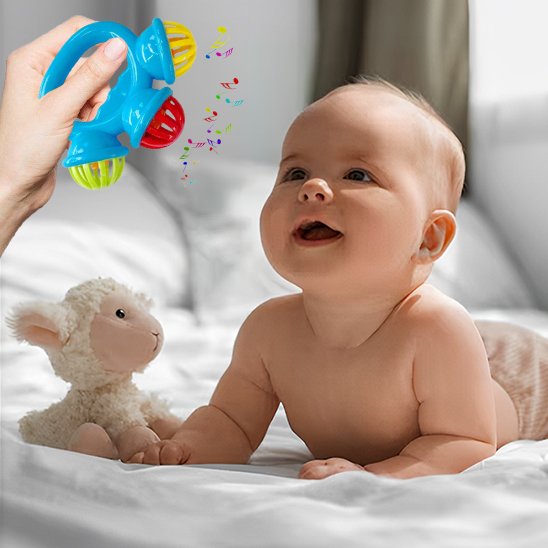 Bébé assis jouant avec un hochet bébé multicolore