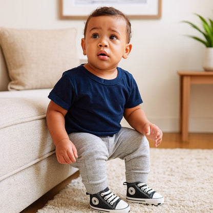 Bébé assis sur le canapé portant des chaussure bébé confort pour l’apprentissage de la marche