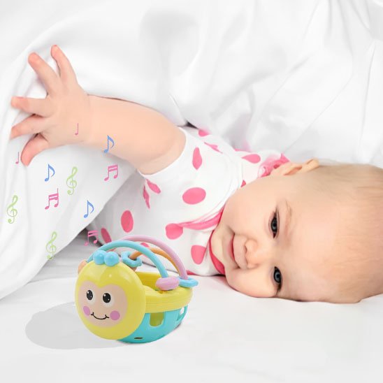 bébé en body jouant avec le hochet Tripopi™ coloré