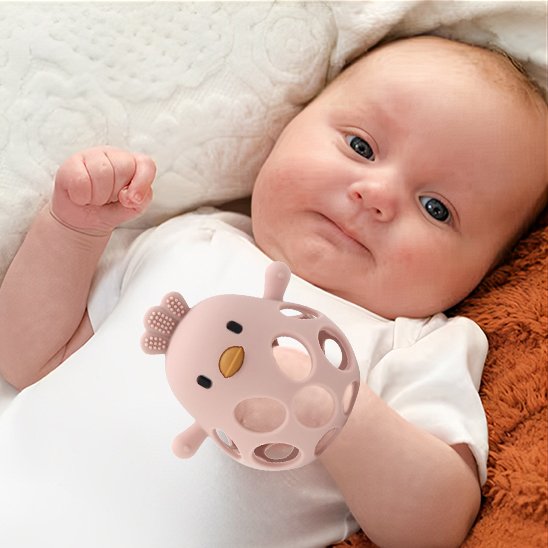 Bébé jouant avec un anneau de dentition en silicone coloré pour apaiser les gencives