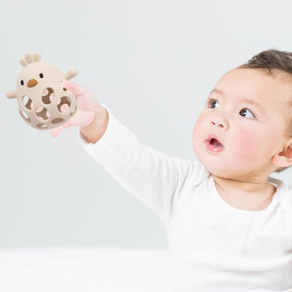 Bébé manipulant un anneau de dentition pastel en silicone alimentaire