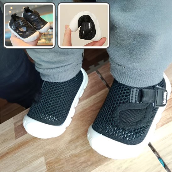 Chaussure bébé noire portée par un enfant, idéale pour la marche et les sorties quotidiennes.