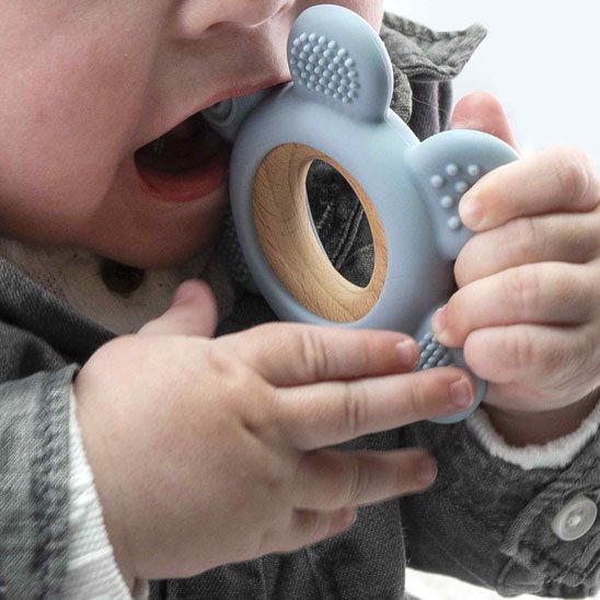 Parent donnant un anneau de dentition en silicone bleu à son bébé